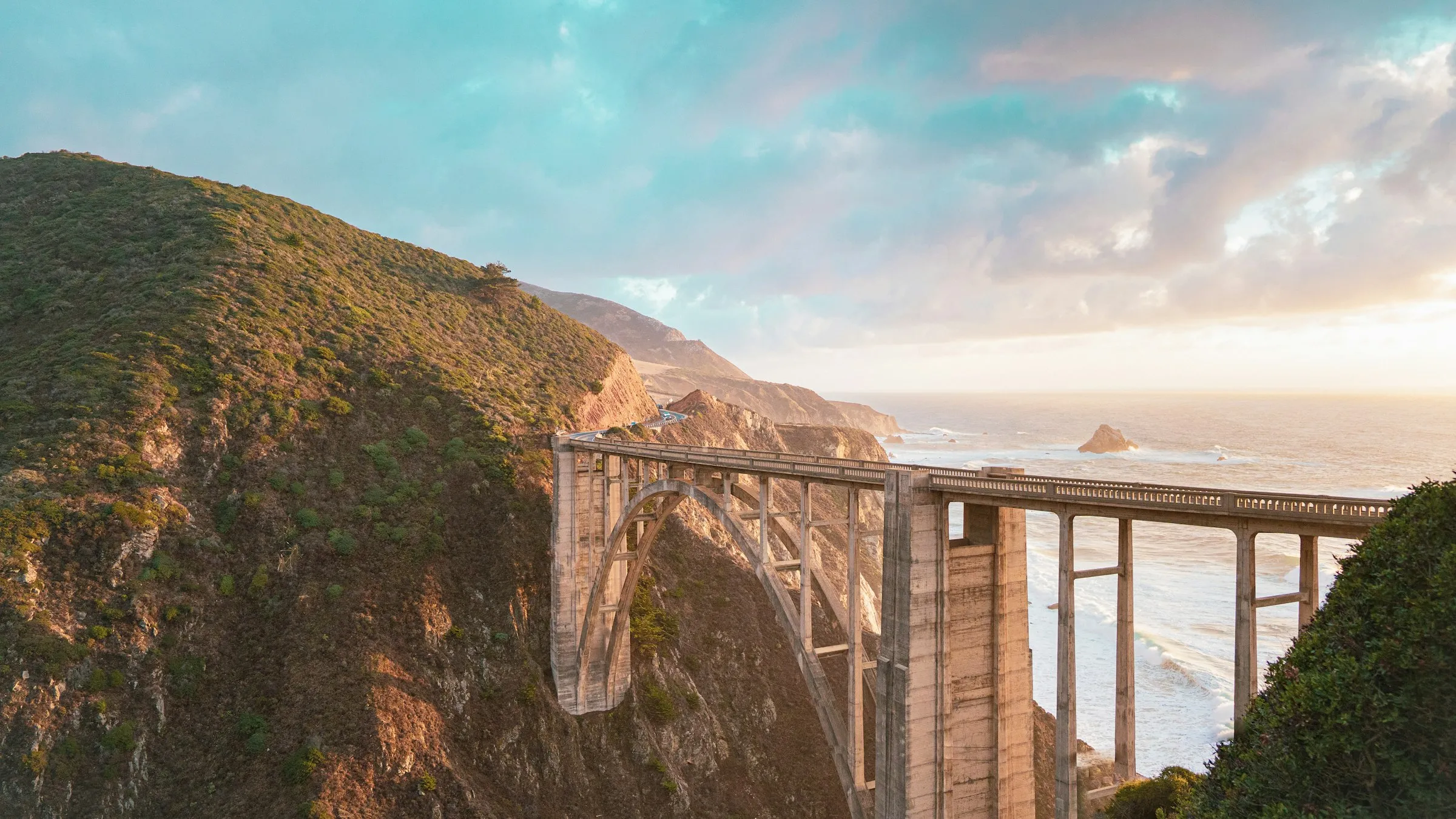 Ponte Bixby sobre o desfiladeiro na Highway 1, com o Pacífico ao fundo na luz dourada do fim de tarde