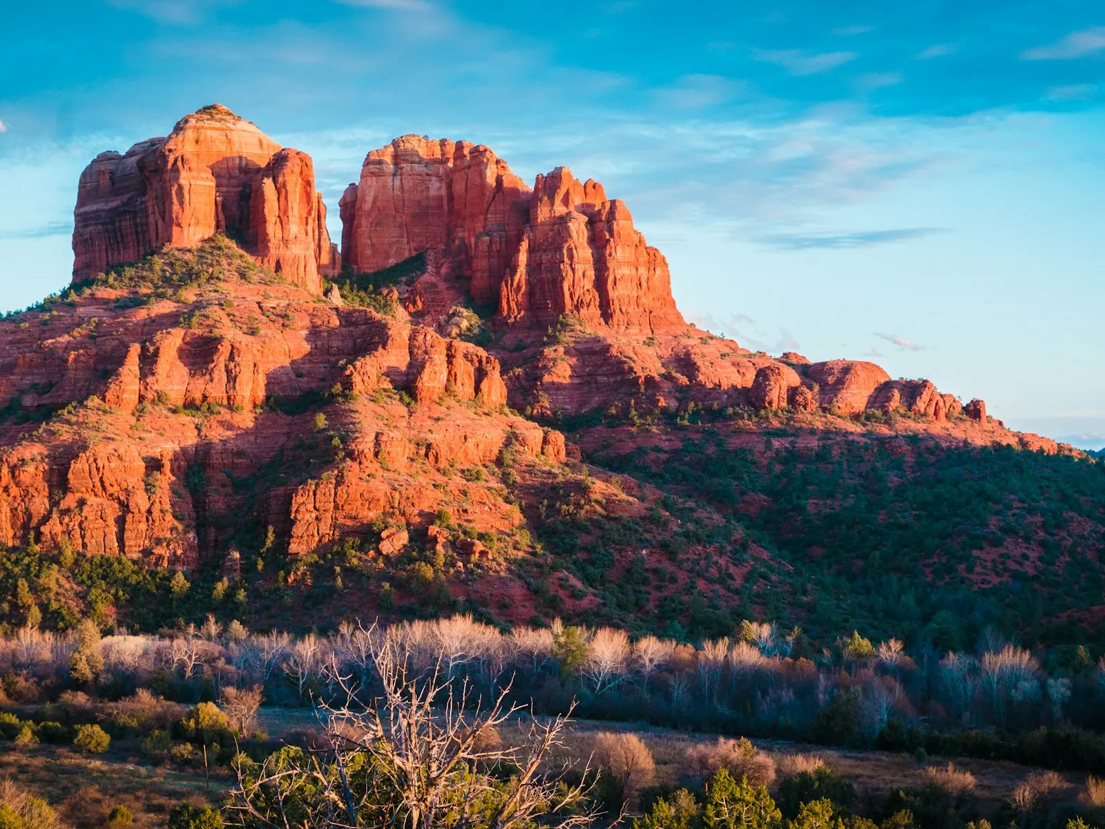 Cathedral Rock, em Sedona, com as rochas vermelhas acesas pelo sol baixo e céu azul