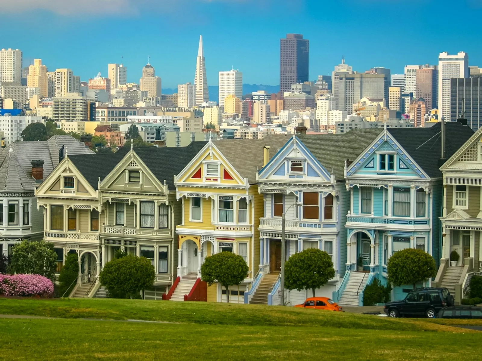 As Painted Ladies, casas vitorianas coloridas diante do gramado da Alamo Square, com os prédios do centro ao fundo