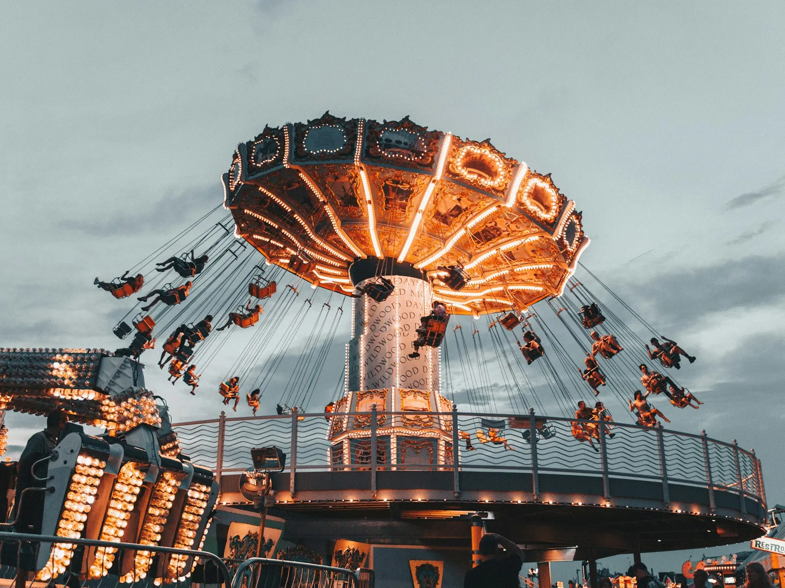 Brinquedo de cadeiras giratórias todo iluminado num parque de diversões ao anoitecer